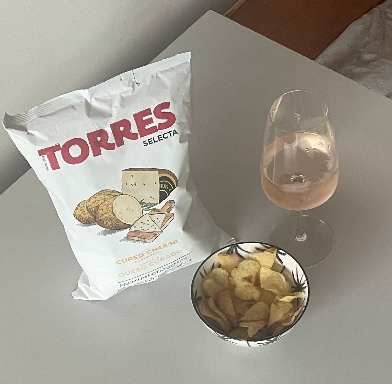 chips torres au manchego servis dans un bol élégant pour l'apéritif avec un verre de vin