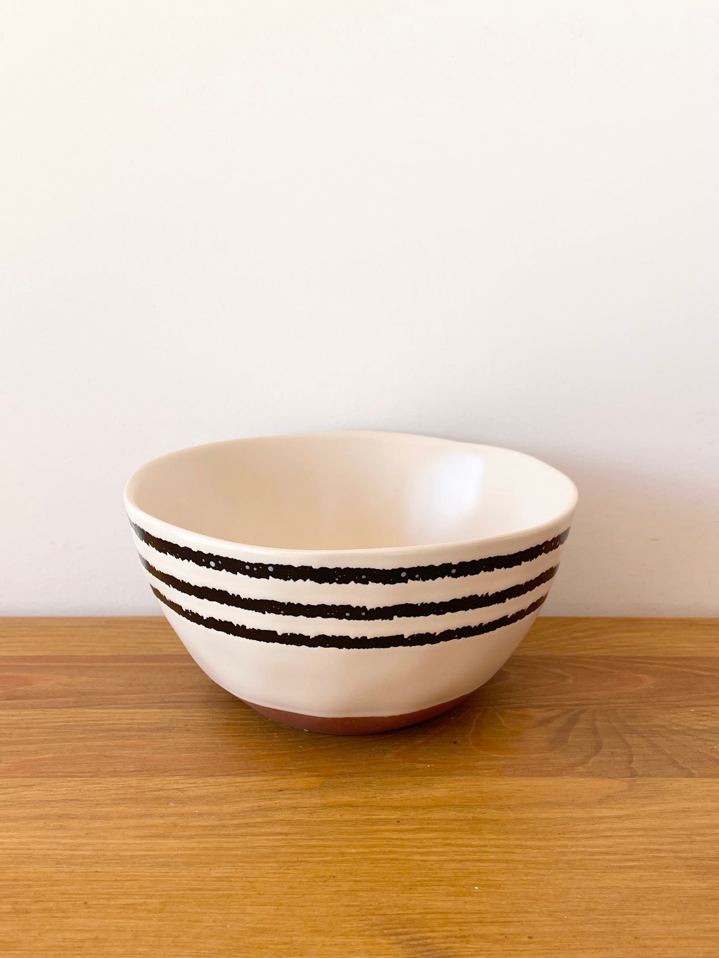 Bol en céramique beige avec fines rayures noires. grand format pour les chips à l'apéro ou pour le petit déjeuner. accessoire apéro du coffret Truffe Lover Maison BAM
