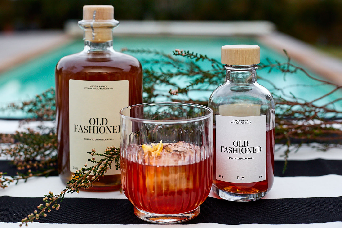 verre vintage rempli d’un Old Fashioned, garni de glaçons et d’une tranche d’orange.