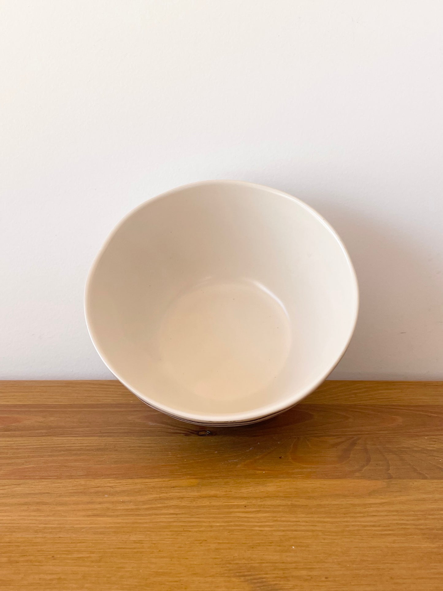 le bol en céramique à pois noirs est de couleur beige à l'intérieur 