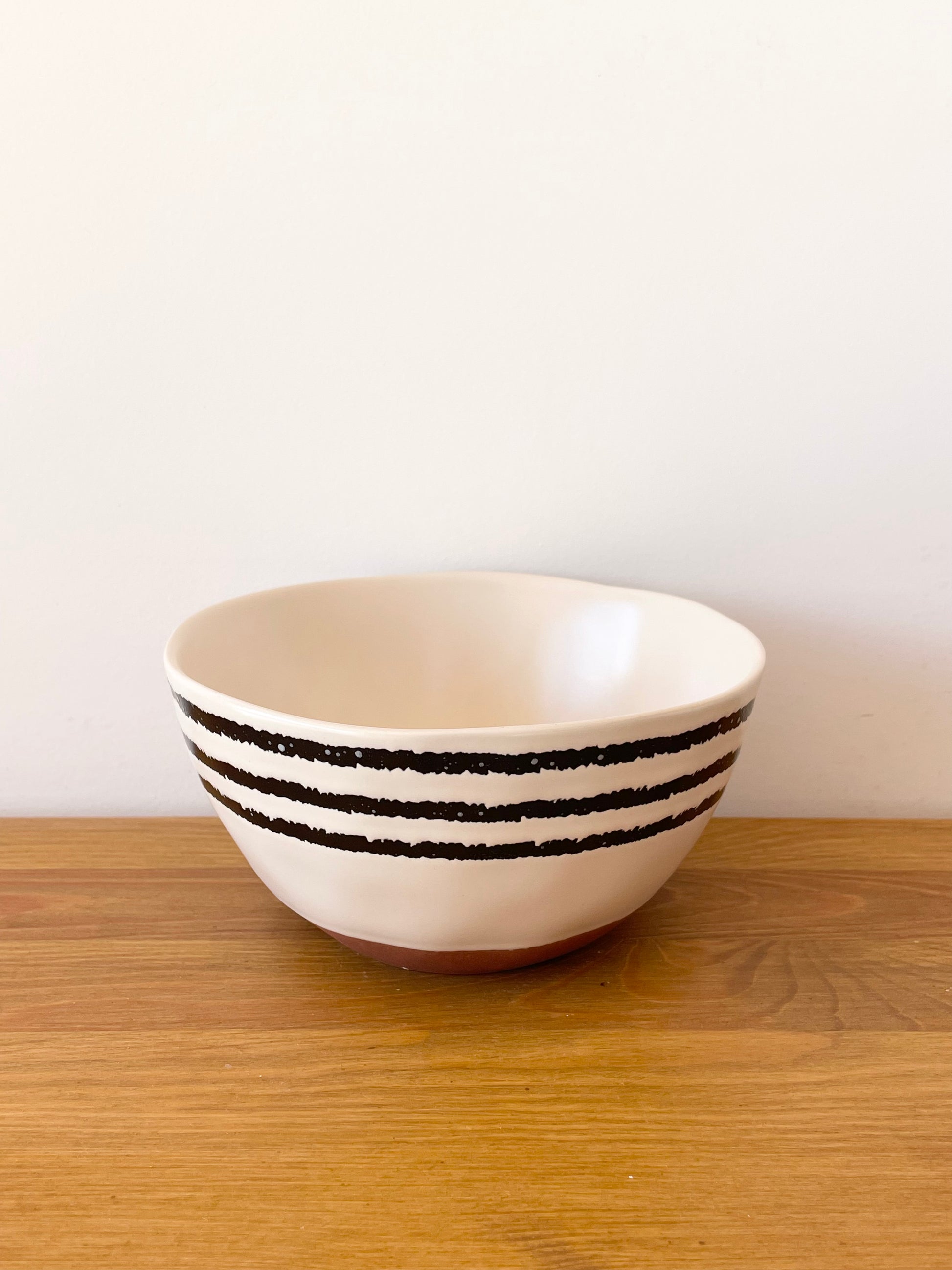 Bol en céramique beige avec fines rayures noires. grand format pour les chips à l'apéro ou pour le petit déjeuner. accessoire apéro du coffret Truffe Lover Maison BAM