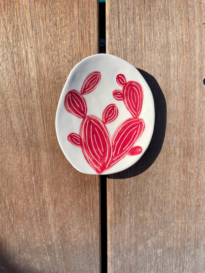 coupelle artisanale en céramique, cactus rouge sur fond blanc, posé sur une terrasse en bois