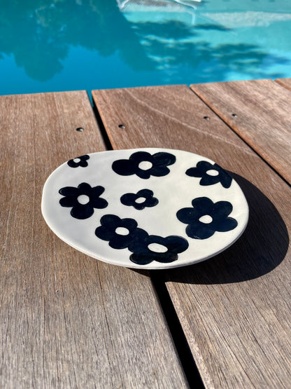 coupelle artisanale en céramique, fleurs noires sur fond blanc, posée sur une terrasse en bois