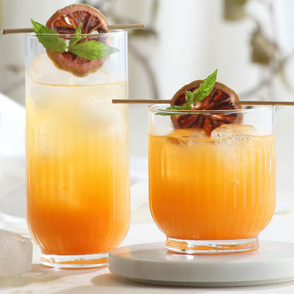 un verre haut type long drink et un verre bas type verre à eau ou jus, remplis de cocktails sans alcool avec orange séchée, menthe et glaçons
